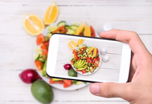 Hands taking photo mediterranean salad with smartphone. — Stock Photo, Image