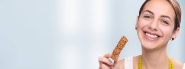 Genç kadın yeme müsli bar . 
