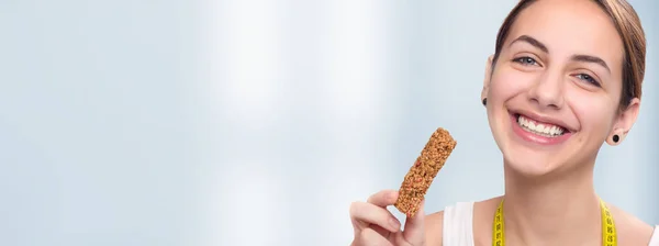 Young woman eating muesli bar . — Stock Photo, Image