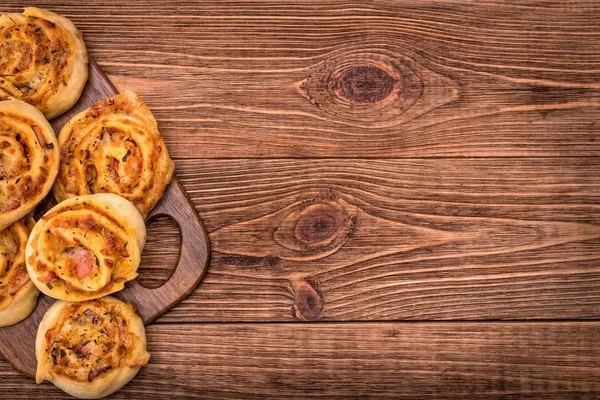 Rolos de presunto e queijo em tábua de madeira . — Fotografia de Stock