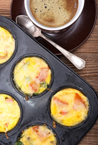 Bolos de ovo de café da manhã com presunto, queijo e verduras. Xícara de café . — Fotografia de Stock