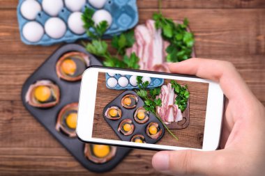 Pastırmalı çörek teneke ile smartphone içinde pişmiş yumurta alarak eller fotoğraf.