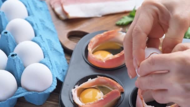Concept of cooking eggs with bacon in muffin tin . — Stock Video