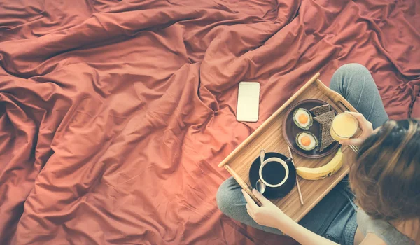 Jeune femme prend un petit déjeuner sain au lit . — Photo