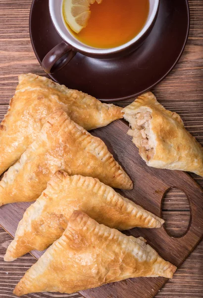 Triangle meat pies with cup of tea . — Stock Photo, Image