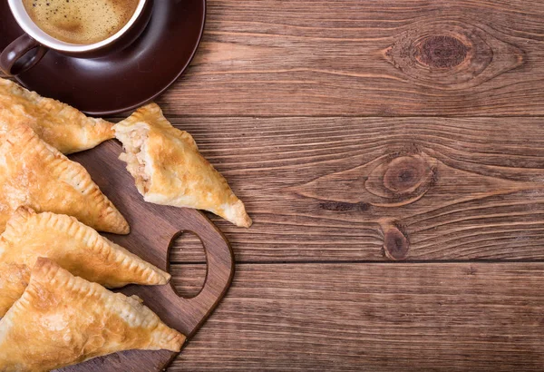 Triangle meat pies with cup of coffee . — Stock Photo, Image