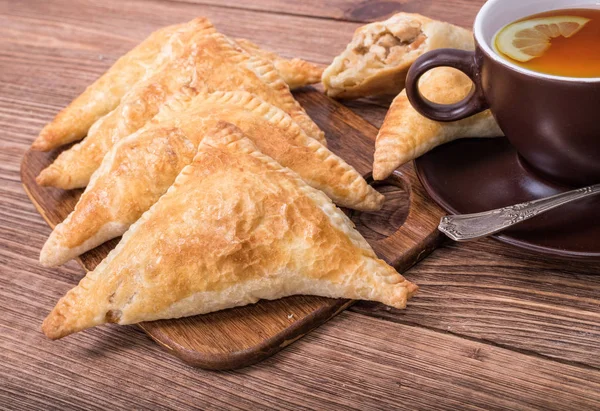 Triangle meat pies with cup of tea . — Stock Photo, Image