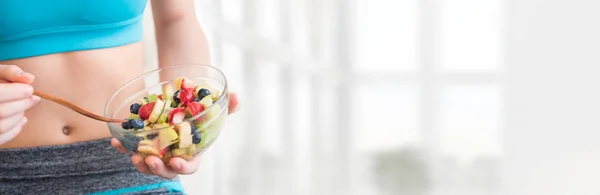 Mujer joven comiendo una ensalada de frutas saludable después del entrenamiento . —  Fotos de Stock