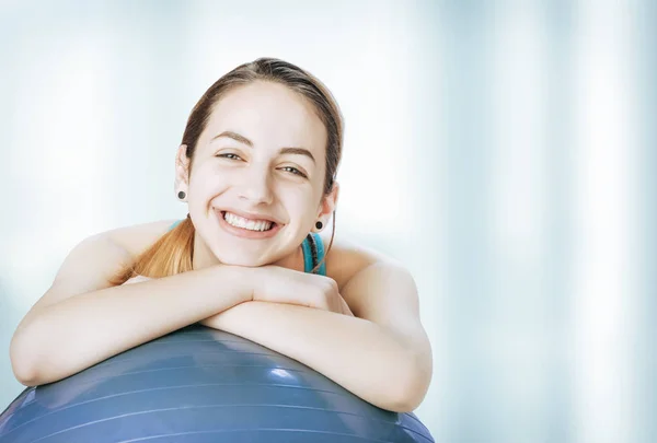 Jovem mulher descansando em uma bola de fitness após o treino . — Fotografia de Stock