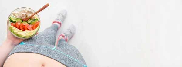 Young woman is resting and eating a healthy salad after a workout. — Stock Photo, Image