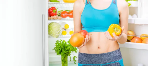 Young woman staying near the fridge full of healthy food. — Stock Photo, Image
