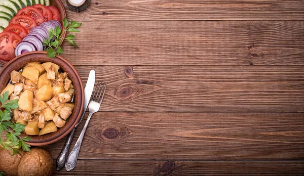 Viande cuite avec pommes de terre dans un bol sur fond en bois . — Photo