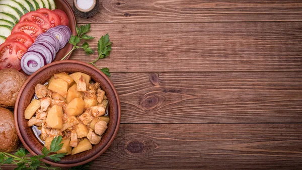 Viande cuite avec pommes de terre dans un bol sur fond en bois . — Photo