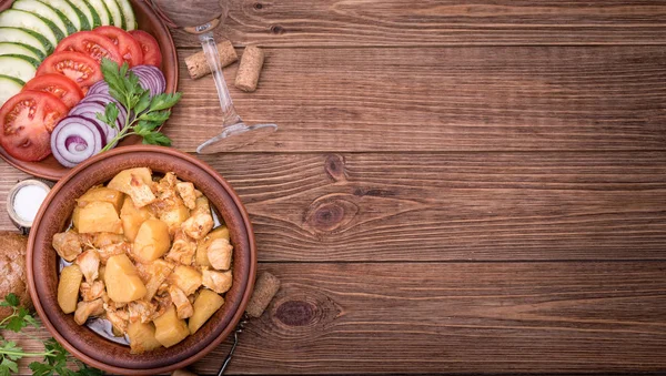 Carne cozida com batatas em tigela no fundo de madeira . — Fotografia de Stock