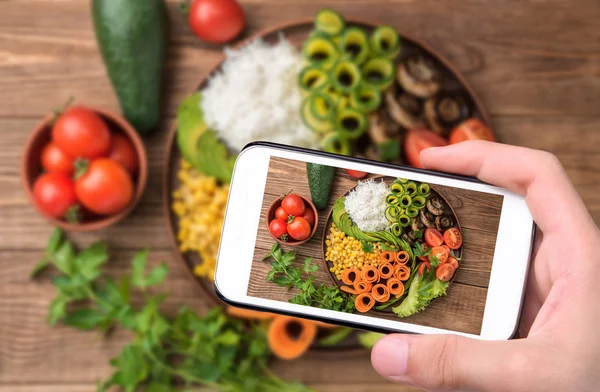 Hands taking photo Buddha bowl of mixed vegetable with smartphone. — Stock Photo, Image