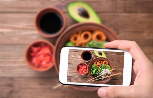 Hands taking photo sushi bowl with smartphone. — Stock Photo, Image