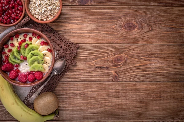 Haferbrei mit Banane, Kiwi, Himbeeren und Granat für ein gesundes Frühstück. — Stockfoto