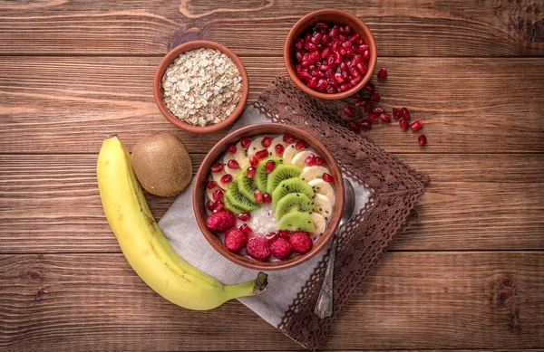 Haferbrei mit Banane, Kiwi, Himbeeren und Granat für ein gesundes Frühstück. — Stockfoto