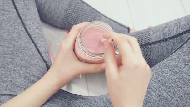 Mujer joven bebiendo batido sano fresco después del entrenamiento . — Vídeo de stock