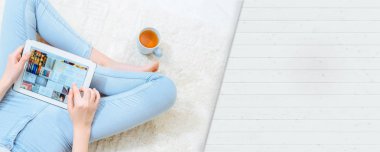 Genç kadın yerde evde istirahat ve tablet kullanma .