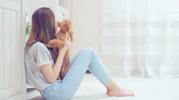 Jeune fille se repose avec un chien sur le sol à la maison  . — Video