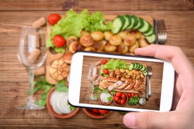 Izgara sosis ve şarap kadehi ile ahşap tahta sebze.