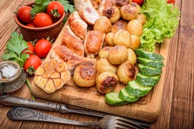 Izgara sosis ve sebze ahşap tahta üzerinde.