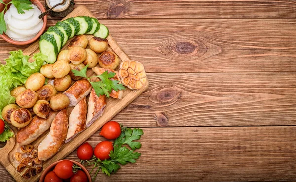 烤的香肠、 蔬菜上的木板. — 图库照片