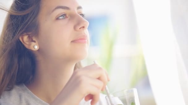 Mladá žena pít detoxikační voda limetkou a mátou . — Stock video