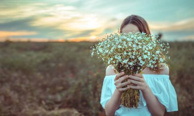 Güzel kız bir alanda duruyor.