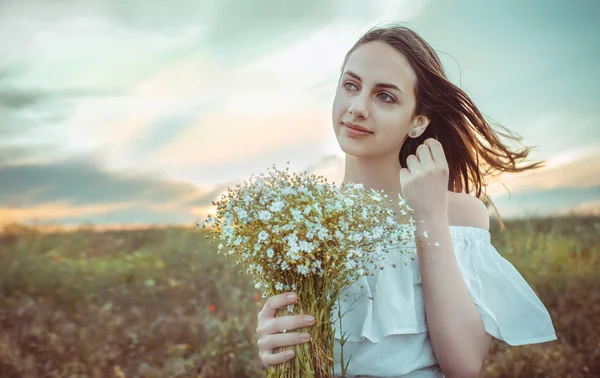 Krásná dívka stojí v poli. — Stock fotografie