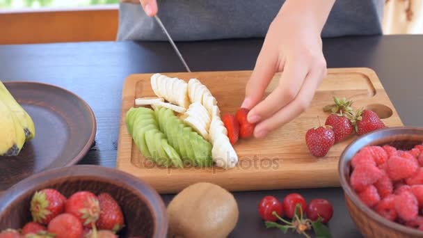 Female hands slicing strawberry. — Stock Video