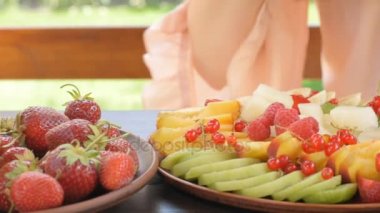 Genç kadın meyve salatası yemek. 