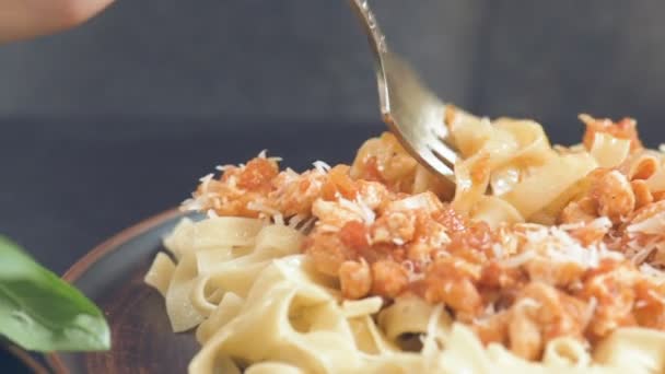 Mangiare un piatto di pasta tradizionale italiana, servito con un sugo a base di carne  . — Video Stock