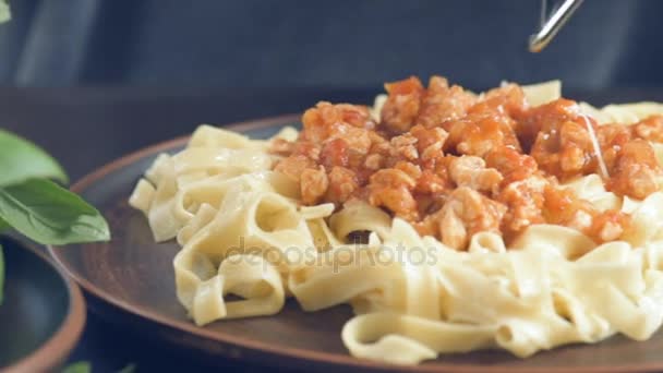 Frau reibt Käse mit Stahlreibe auf der Pasta. — Stockvideo