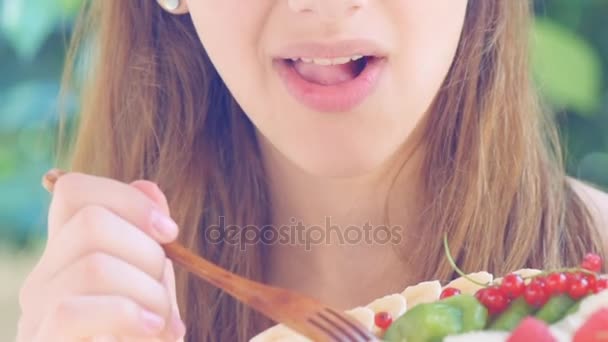 Mujer joven comiendo ensalada de frutas . — Vídeo de stock