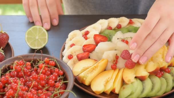 Manos sirviendo plato de frutas y bayas  . — Vídeos de Stock