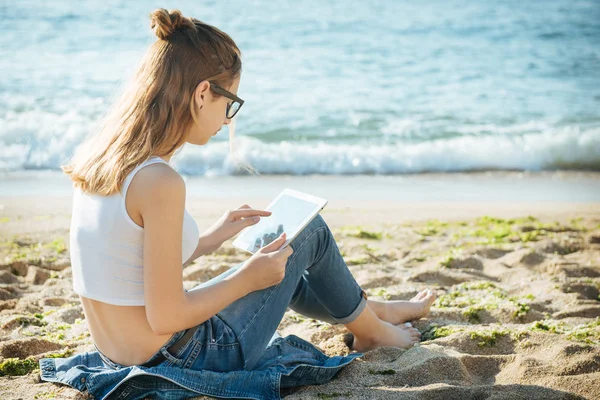 Flickan med en digital tablett vid havet. — Stockfoto