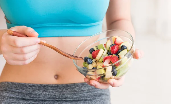 Young woman eating a healthy fruit salad after workout. — Stock Photo, Image