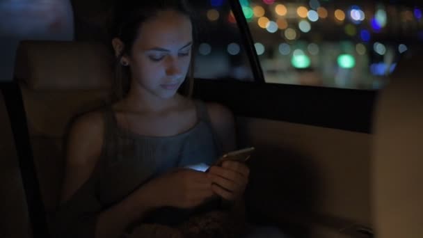 Young adult female in taxi using smart phone. — Stock Video