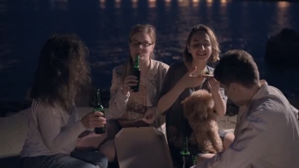 Fröhliche Freunde auf einer Party, Pizza essen und Bier trinken. — Stockvideo