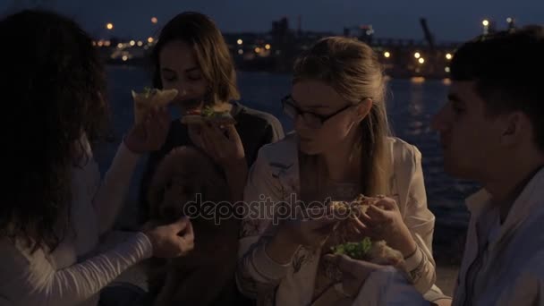 Vrolijke vrienden op een feestje eten van pizza. — Stockvideo