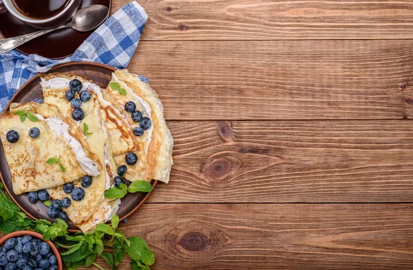 Pannenkoeken gevuld met cottage kaas met bosbessen en kopje koffie. — Stockfoto