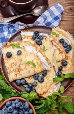 Yaban mersini ve kahve fincan süzme peynir ile doldurulmuş krep. 