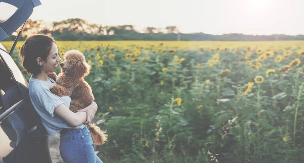 Ung kvinna med hennes hund stå nära bilen . — Stockfoto