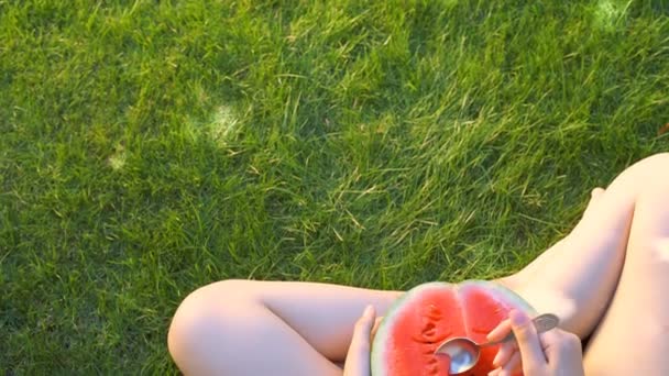 Jonge vrouw eet de helft een rode watermeloen . — Stockvideo