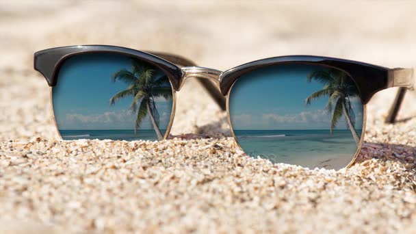 Kinograf - okulary przeciwsłoneczne na piasku. Zdjęcie w ruchu. — Wideo stockowe