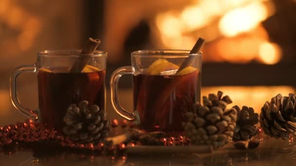 Cinemagraph - Mulled wine glasses on table in front of burning fireplace. — Stock Video