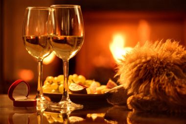 Nişan yüzüğü şömine arka plan üzerinde kırmızı kutu ile iki şarap kadehlerin. 