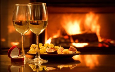 Nişan yüzüğü şömine arka plan üzerinde kırmızı kutu ile iki şarap kadehlerin. 